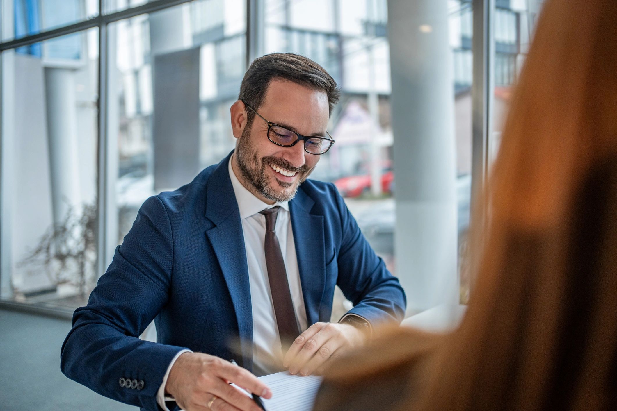 Client signing a document during a professional meeting